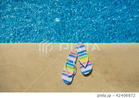 Colored summer sandals near blue pool Colored summer sandals near blue pool 42406872