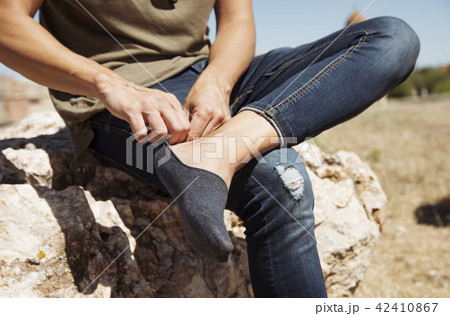 young man putting on or taking off his sock 42410867