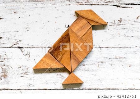 Tangram puzzle in bird shape on old white wood 42412751