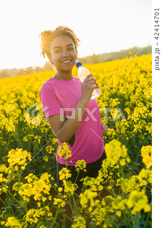African American Girl Drinking Water at Sunset 42414701