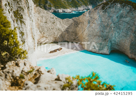 Famous shipwreck on Navagio beach with turquoise blue sea water surrounded by huge white cliffs Famous shipwreck on Navagio beach with turquoise blue sea water surrounded by huge white cliffs 42415295