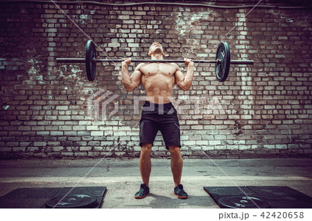Muscular fitness man doing deadlift a barbell over his head in outdoor, street gym. Functional Muscular fitness man doing deadlift a barbell over his head in outdoor, street gym. Functional 42420658