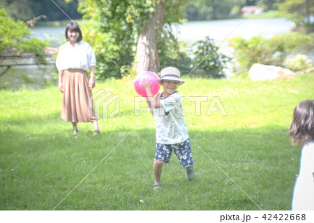 公園でボール遊びをする親子の写真素材