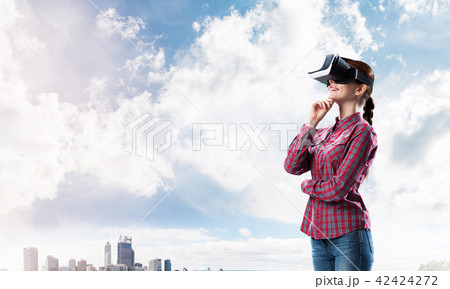 Girl in checked shirt wearing VR glasses experiencing another reality Girl in checked shirt wearing VR glasses experiencing another reality 42424272