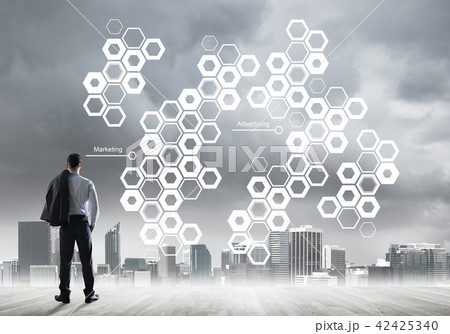 Pensive businessman looking at user interface against modern city background Pensive businessman looking at user interface against modern city background 42425340