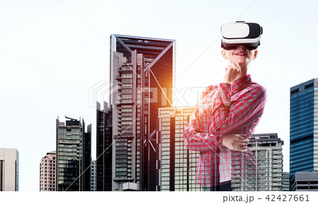 Girl in checked shirt wearing VR glasses experiencing another reality 42427661