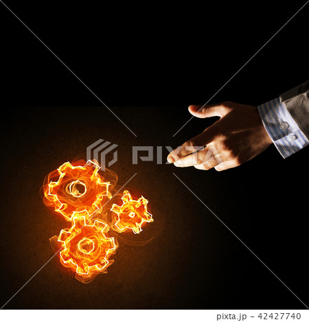 Concept of teamworking or organization presented by fire glowing cogwheels Concept of teamworking or organization presented by fire glowing cogwheels 42427740