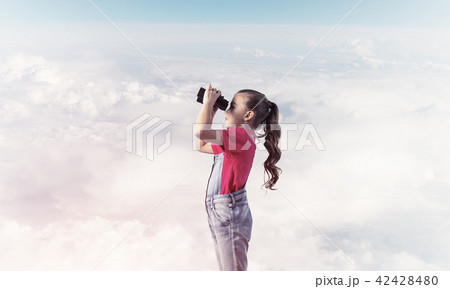 Concept of careless happy childhood with girl looking in binoculars 42428480