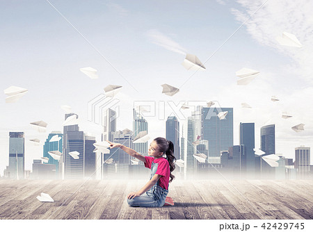 Concept of careless happy childhood with girl pointing with finger at something Concept of careless happy childhood with girl pointing with finger at something 42429745