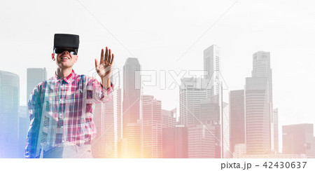 Guy wearing checked shirt and virtual mask stretching hand to touch something 42430637