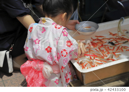 露店の金魚すくい ゆかた姿の女の子の写真素材