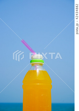 ビーチで飲むオレンジジュースの写真素材