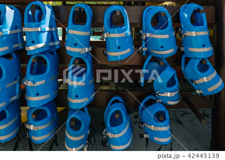 Small blue life jackets for kids are hanging  42445139
