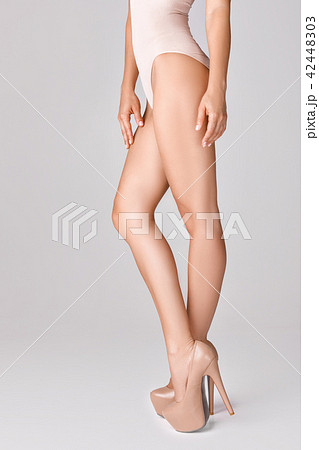 slim female legs wearing high heels 42448303