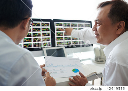 Brokers analyzing data on screen Brokers analyzing data on screen 42449556
