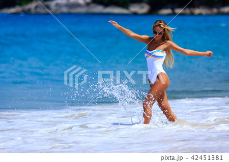 Model in white swimsuit enjoying at the beach 42451381