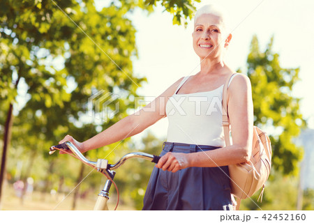 Joyful elderly woman bicycling in park 42452160