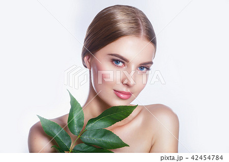 Beautiful woman face portrait with green leaf concept for skin care or organic cosmetics. Studio Beautiful woman face portrait with green leaf concept for skin care or organic cosmetics. Studio 42454784