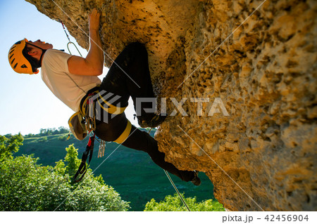 Image of tourist man in helmet clambering up 42456904