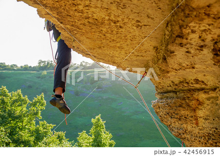 Photo of sporty man climbing rock Photo of sporty man climbing rock 42456915