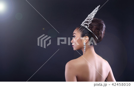 Back rear side view Portrait of Miss Pageant Beauty Contest in Red sequin Evening Gown with Diamond Crown wave hand, Asian Woman fashion make up hair style, studio lighting dark background copy space 42458010
