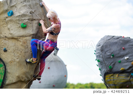 Photo of sporty girl exercising on boulder for rock climbing against sky background with clouds Photo of sporty girl exercising on boulder for rock climbing against sky background with clouds 42469251