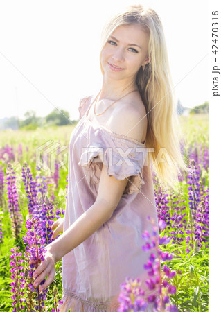 Portrait of a girl on the field with lupines 42470318