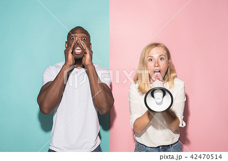 The young emotional angry woman screaming on pink studio background 42470514