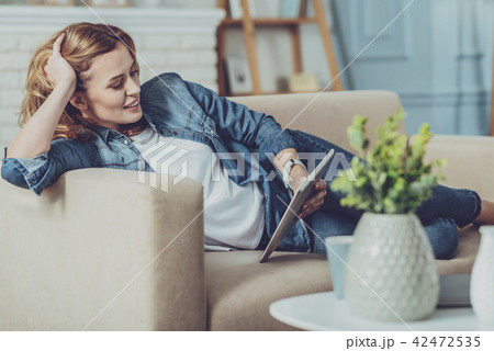 Smiling freelancer watching news in internet Smiling freelancer watching news in internet 42472535