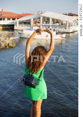 The girl is standing with her back on the pier. Summer, sun, sea, Bulgaria. 42472917