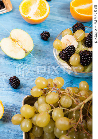 Different fruits and berries on wooden blue table 42475088