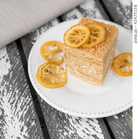 honey cake on rustic backdrop, lemons as decor 42475158
