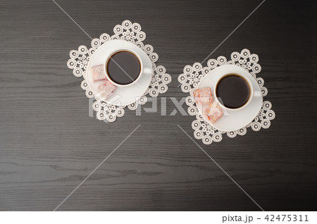 Top view of two mugs of coffee on a saucer 42475311