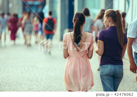 Beautiful girls holding paper coffee cup and enjoying the walk in the city 42476062