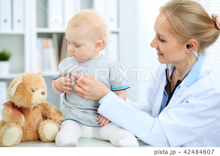 Doctor and patient in hospital. Little girl is being examined by pediatrician with stethoscope Doctor and patient in hospital. Little girl is being examined by pediatrician with stethoscope 42484607