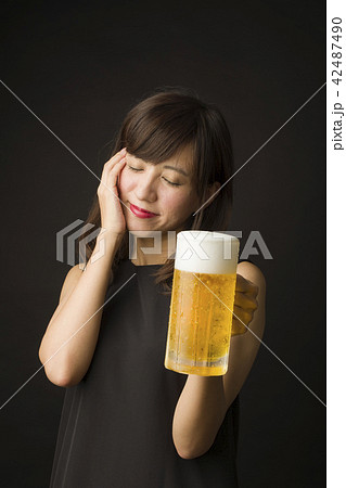 ジョッキのビールを飲む女性 42487490