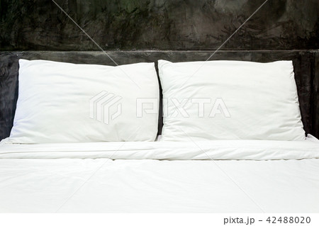 White pillows on a bed and bedding sheets on bed 42488020