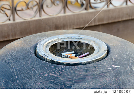 Cigarette butts in ashtray on city street 42489507