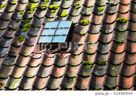 skylight on old ceramic tiles house roof 42490944