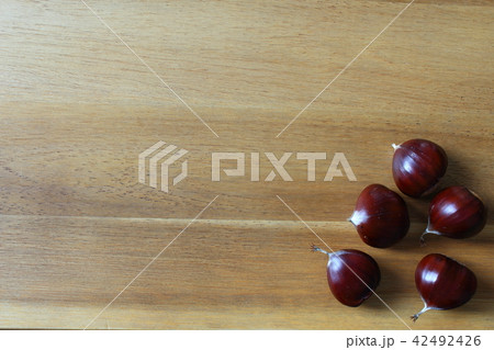 sweet chestnut fruits on a wooden board 42492426