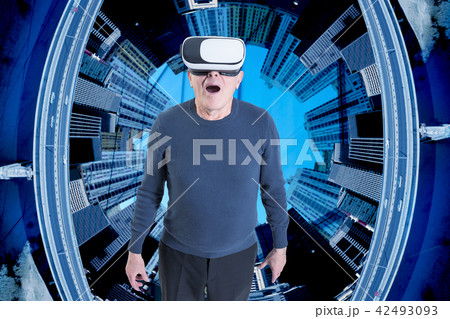 An old man in VR headset against a city buildings background. An old man in VR headset against a city buildings background. 42493093