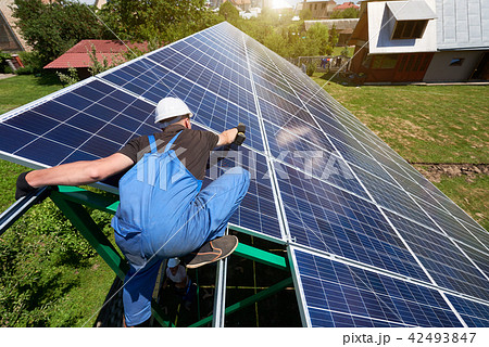 Worker installing solar panel screen during sunny day. Worker installing solar panel screen during sunny day. 42493847