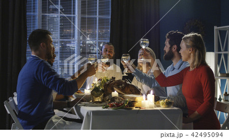 Friends toasting at table on Thanksgiving day Friends toasting at table on Thanksgiving day 42495094