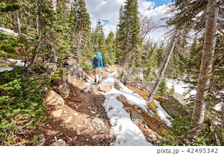 Tourist with backpack hiking on snowy trail Tourist with backpack hiking on snowy trail 42495342