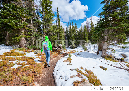 Tourist with backpack hiking on snowy trail 42495344