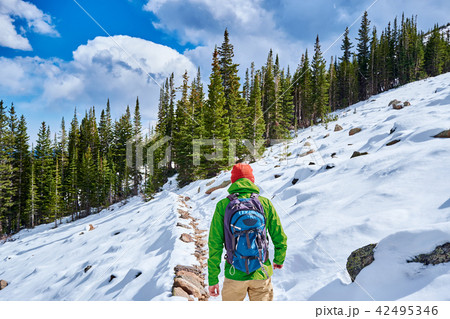 Tourist with backpack hiking on snowy trail Tourist with backpack hiking on snowy trail 42495346