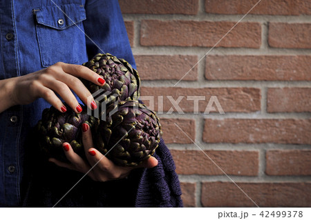 Artichokes are fresh in the hands of women. Bouquet from vegetables. Healthy Italian food. 42499378