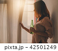 Young asian woman standing beside a window at home 42501249