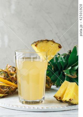 Pineapple fresh juice in glass on a wooden table Pineapple fresh juice in glass on a wooden table 42501920