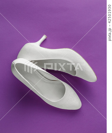 White wedding shoes on purple background 42501930